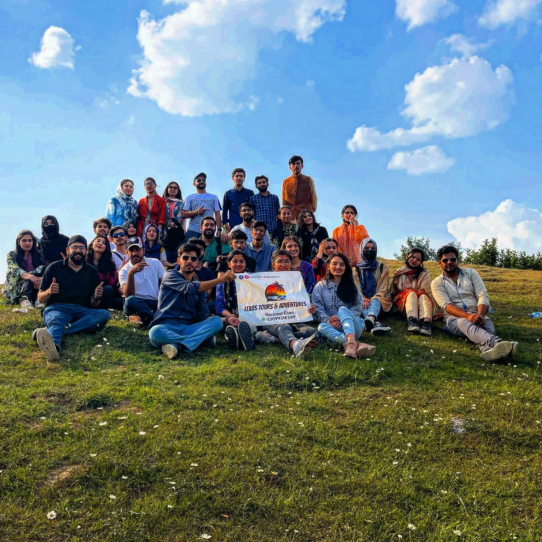 Lexuz Tours group gathered outdoors with a tour banner