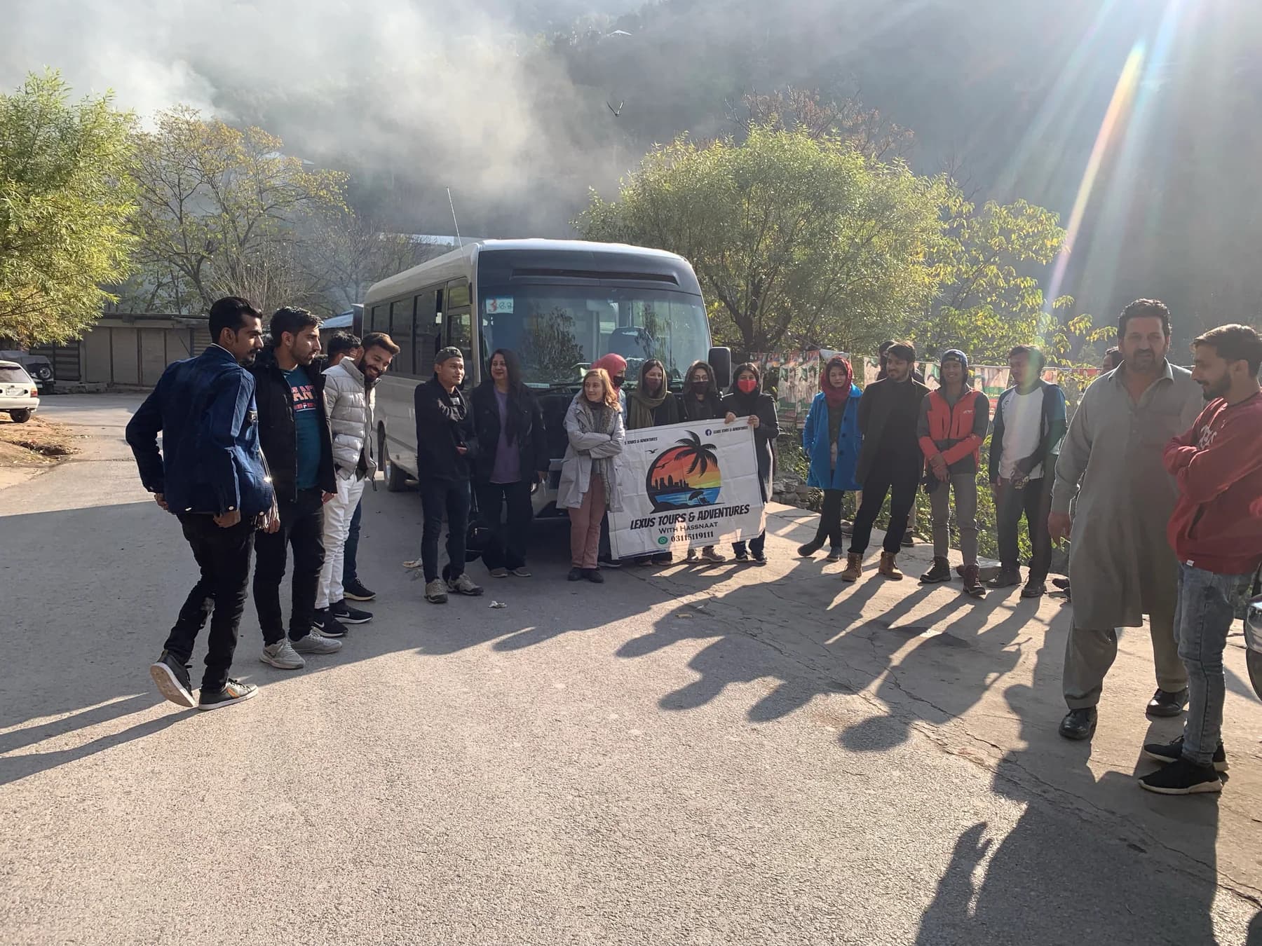 Lexuz Tours group gathered beside a coach in evening light
